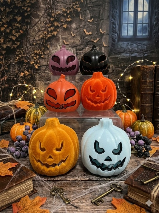 Wholesale display of mini velvet flocked and smooth Halloween pumpkin decorations with carved scary faces on an archival gothic desk backdrop.